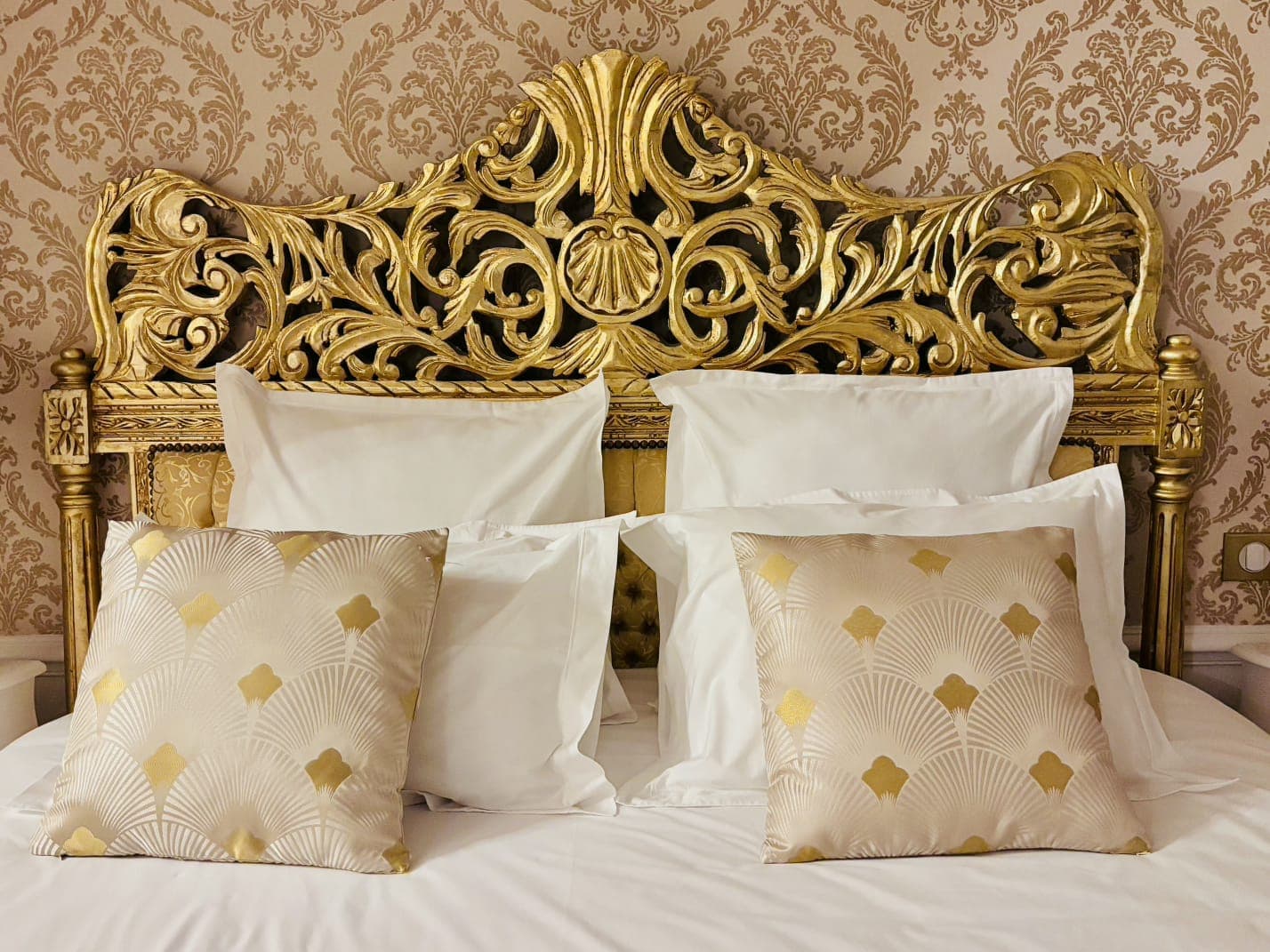 Chambre de prestige — literie raffinée et tête de lit dorée